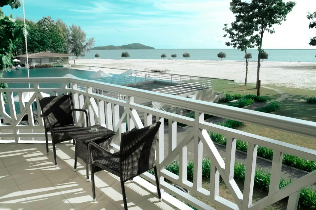 Elegant balcony setting with a stunning view of the ocean and pool, perfect for a serene escape.